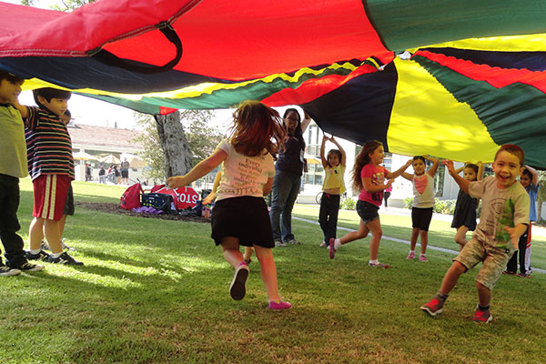 Students play under a tent top on the Whittier College campus.