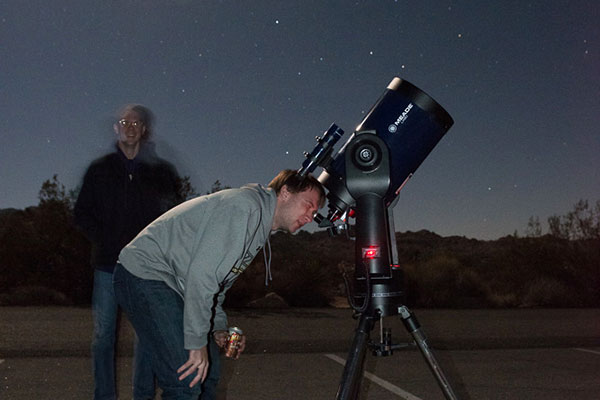 A student looks through a telescope at a star party.