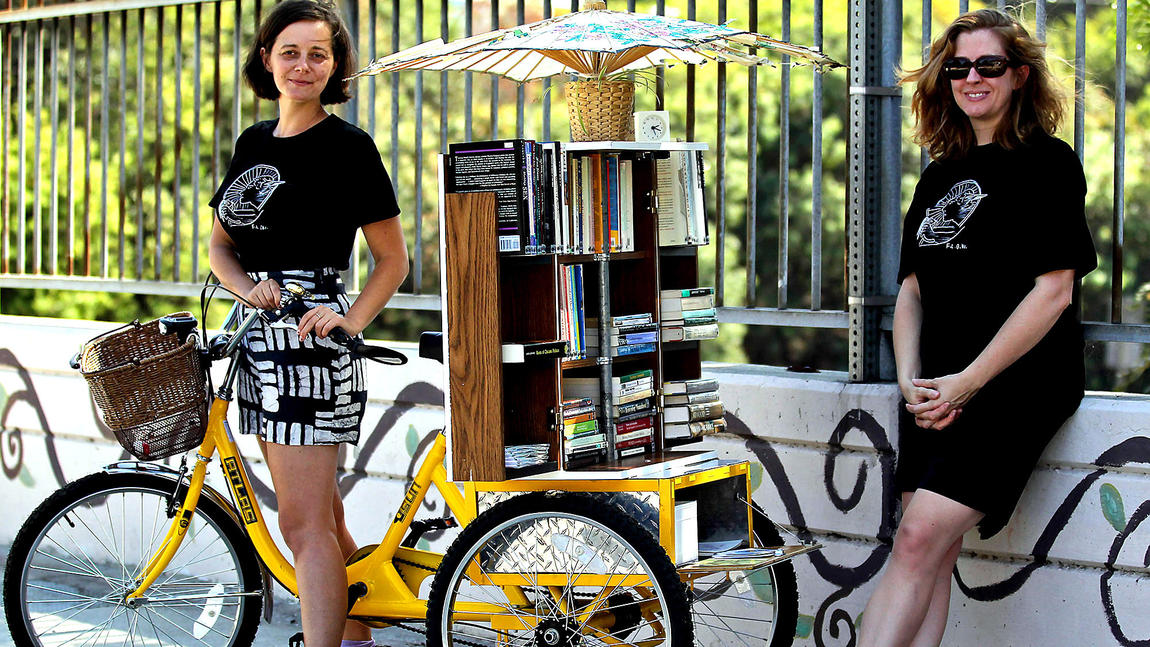 Alumna Dawn Finley (right), Jenn Witte (left) and custom "bookcycle"