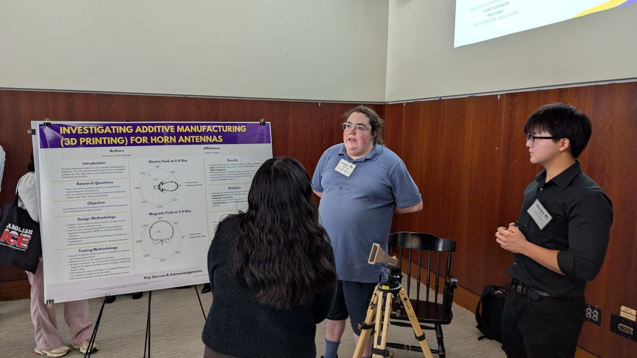 An alumnus and student presenting a poster