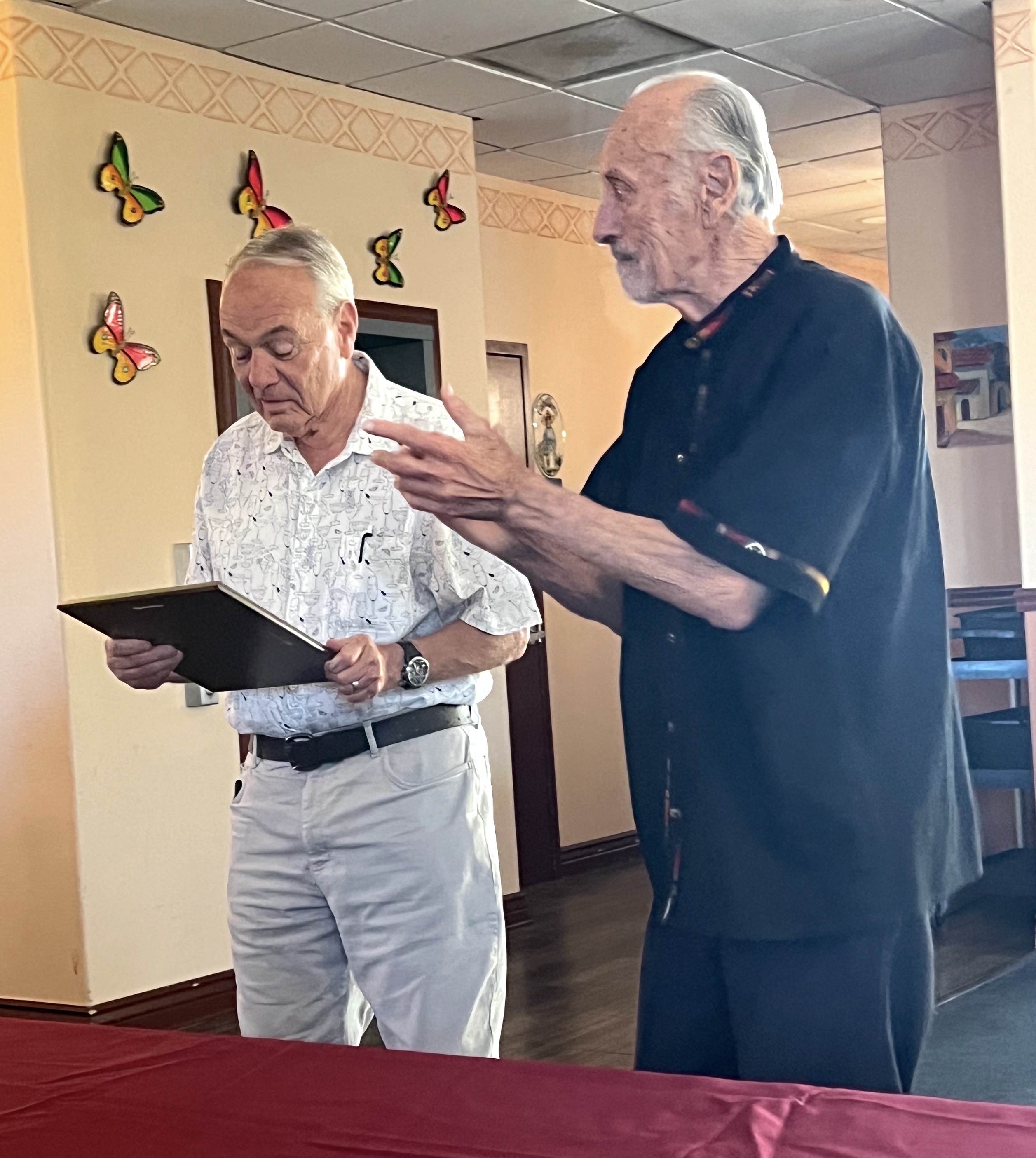 Brian Miles, former basketball manager, receives a Hall of Fame plaque.
