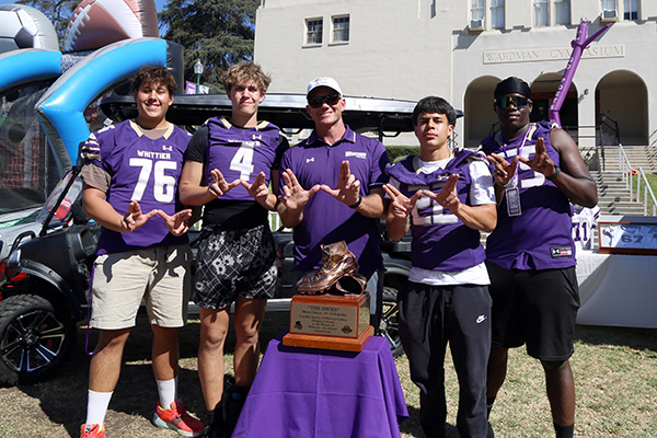 Football coach and players with trophy