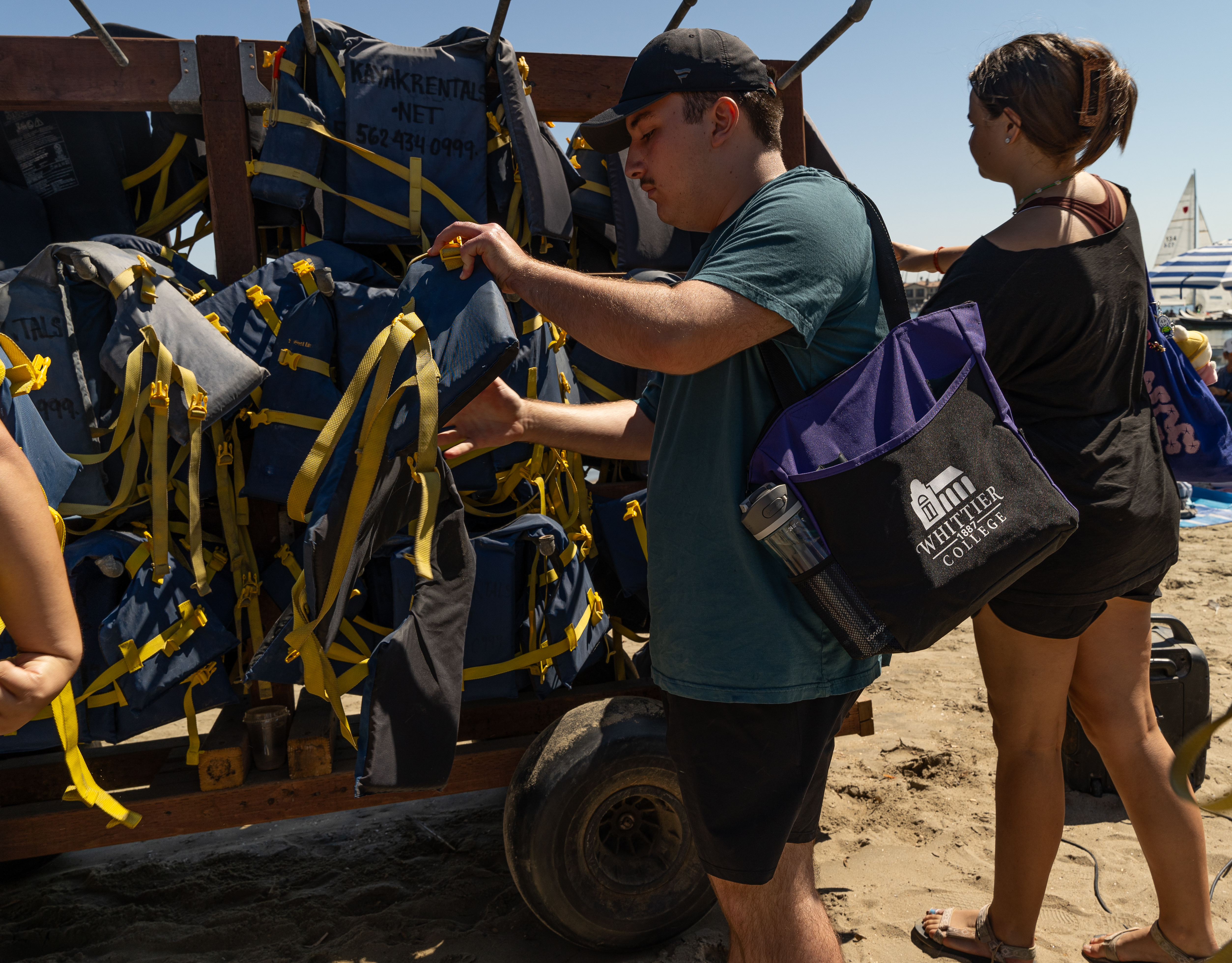 Student with Whittier College tote bag grabbing life vest