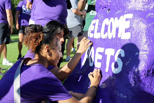 Students signing the Rock.