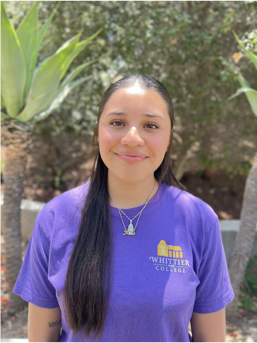 Mia Cordova standing in front of plants wearing Whittier College shirt