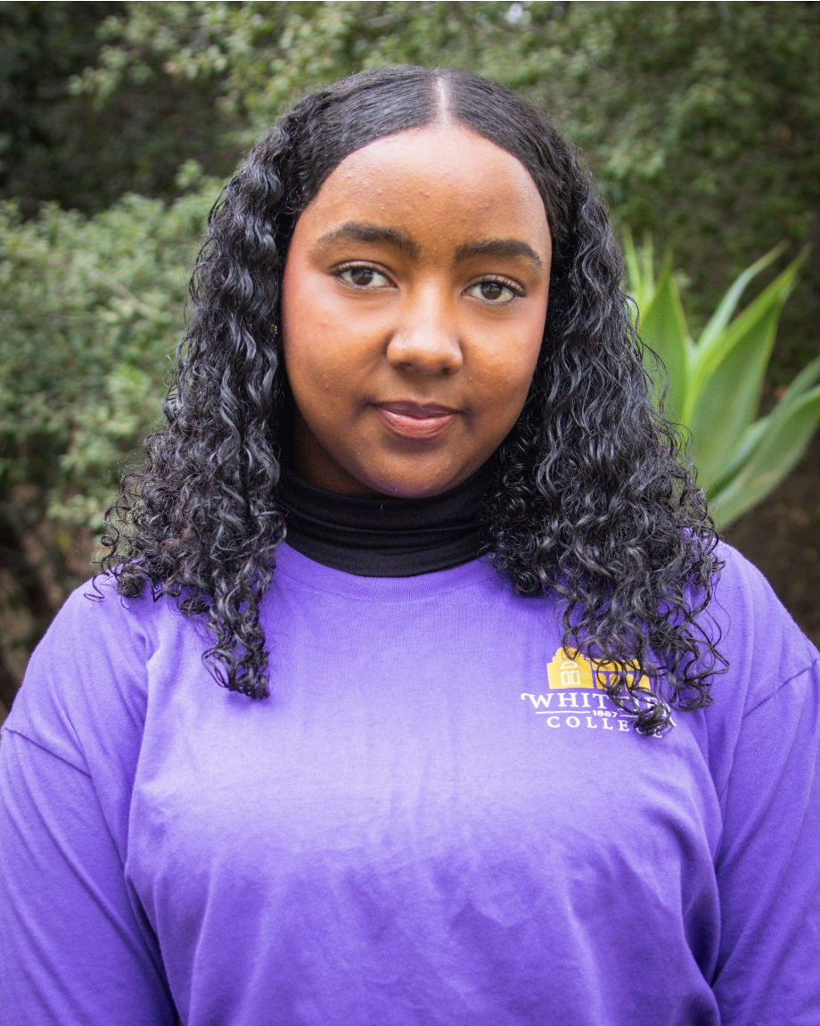 Arsema Haile standing in front of plants in Whittier College shirt
