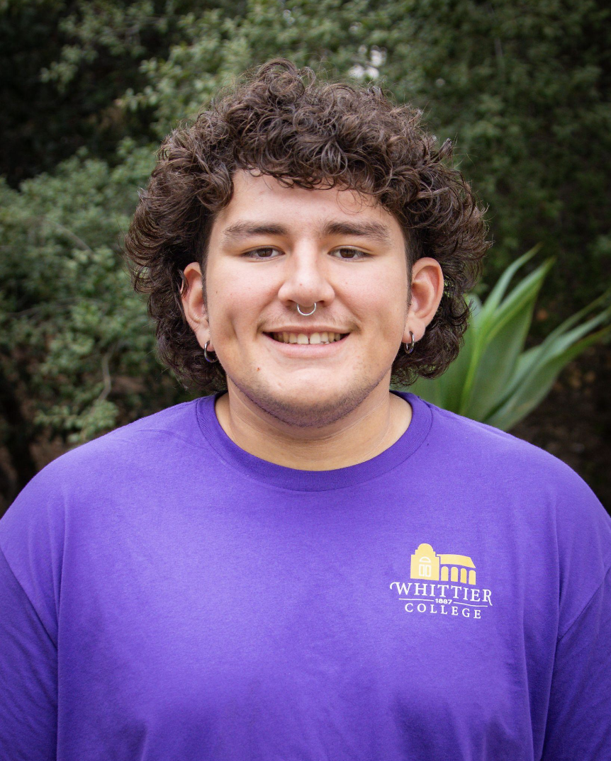 Aidan Chaidez standing in front of plants wearing Whittier College shirt