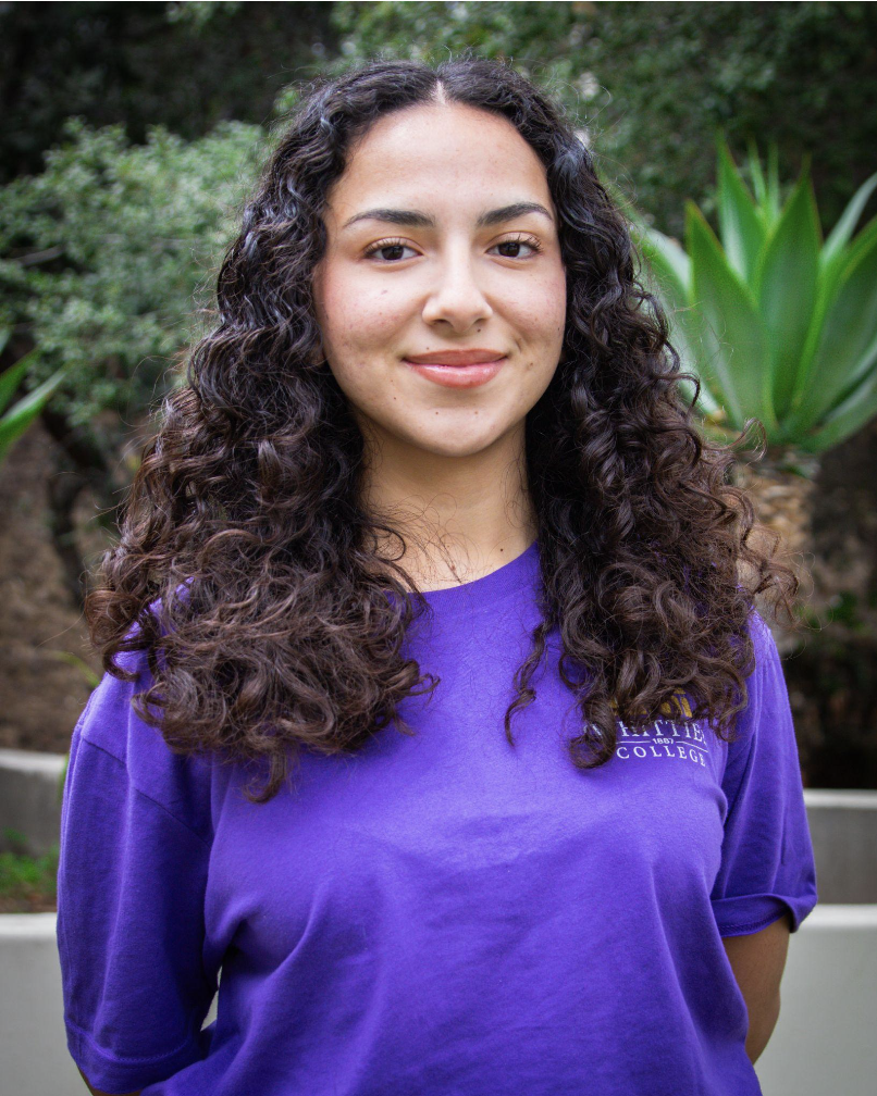 Ava Melendrez standing in front of plants wearing a Whittier College shirt