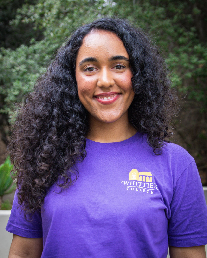 Barbara Lozano standing in front of plants wearing a Whittier College shirt