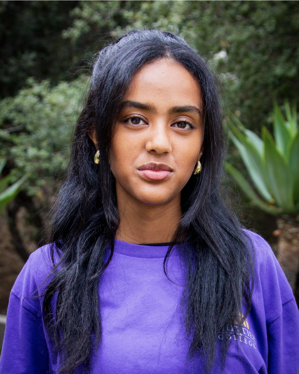 Christian Wondossen standing in front of plants wearing a Whittier College shirt