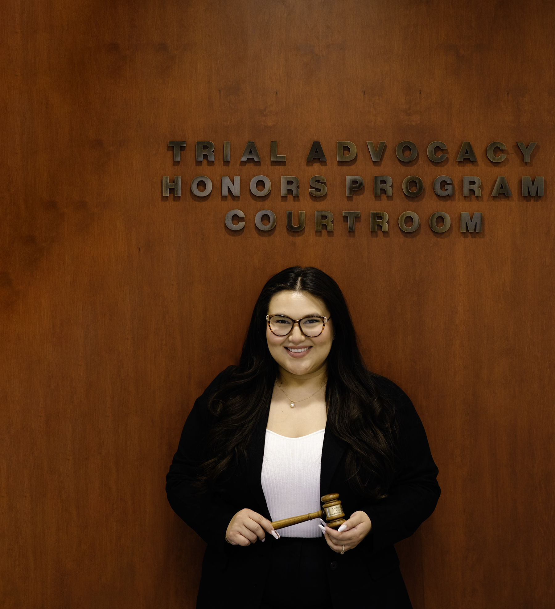 Destiny in front of wall holding gavel at court house