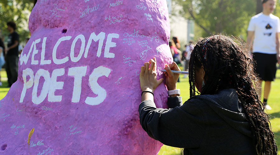Student signing the Rock