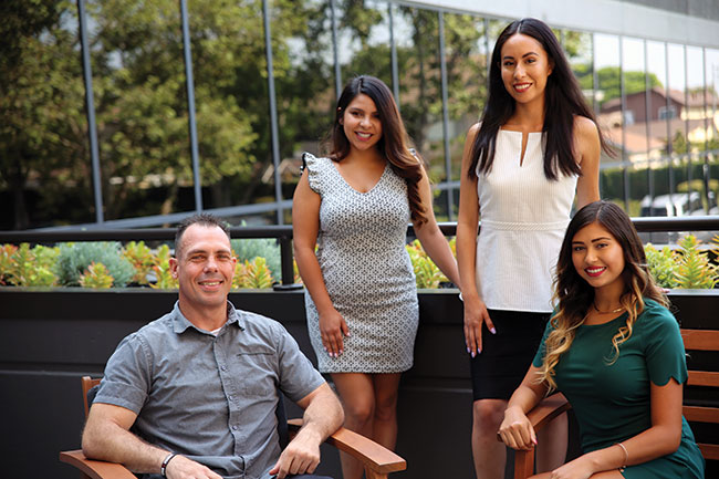 Four alumni posing for a photograph.