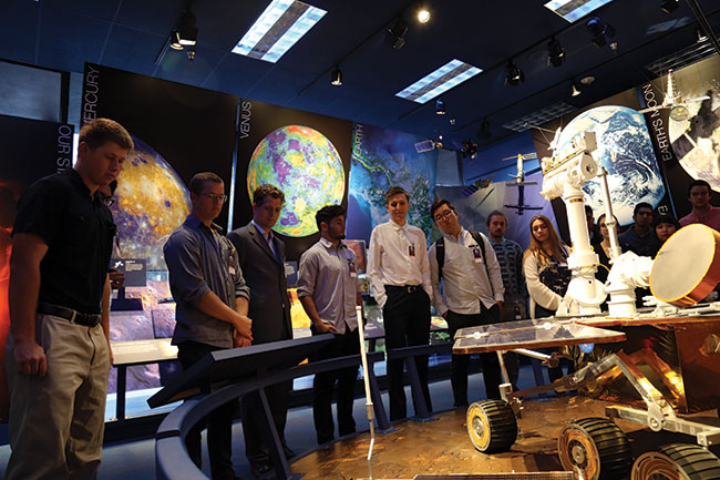 Students look at a model of a rover at Jet Propulsion Laboratory.