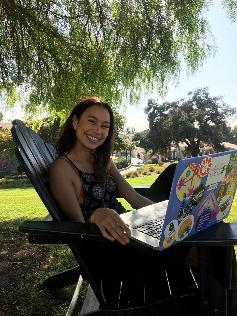 Genesis in a chair with her laptop on founders hill