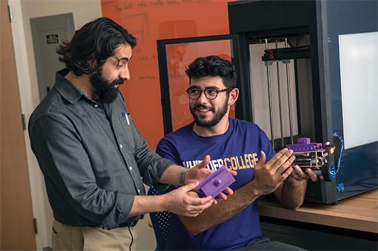 Professor and student look at 3D-printed robots