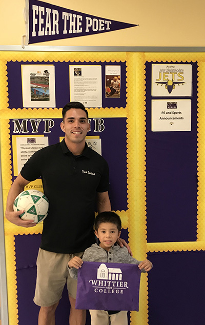 Adam Sandoval with a boy holding a Whittier College sign.