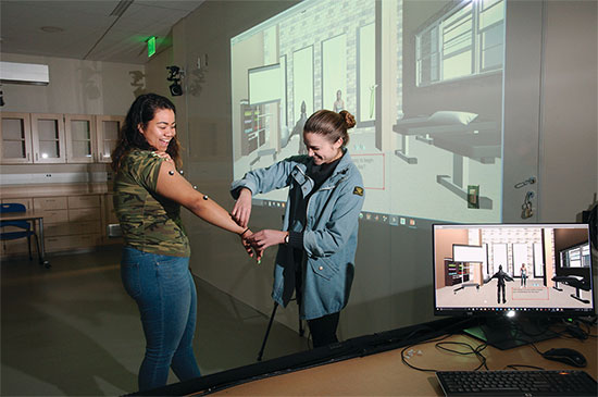 Frankie Capraro applies motion-capture sensors to Bailey Russ' arm in the kinesiology lab.