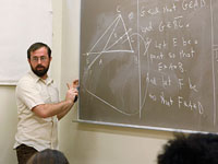 Professor writing on chalkboard