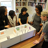 Students examine art exhibit model