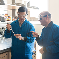 A student and a professor in a chemistry lab.