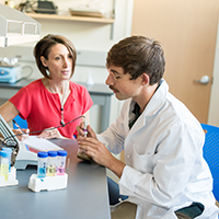 Matthew Voegtle and Professor Cinzia Fissore study a soil specimen in a laboratory.