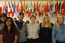 President Sharon D. Herzberger stands with students in the Campus Inn flanked by the 50 new flags respresenting the schools commitment to the international community. 