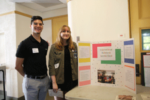 Participants pose beside their poster board presentation