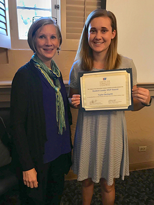 Rebecca Romberger and Taylor Beckwith, who is holding up an award certificate.