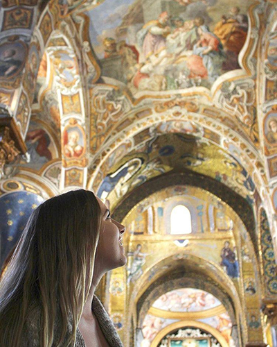 Student looking up at painted ceiling of a cathedral in Europe.