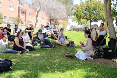 musicians and students sitting on the lawn