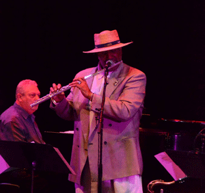 Professor Danili Lozano plays the flute on stage