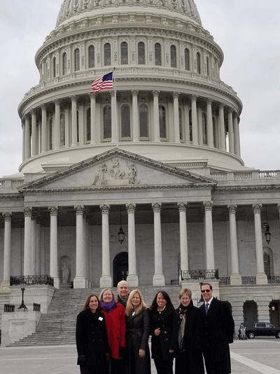 group stands in front of state capitol