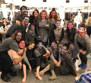 Students with faces painted gather backstage for a photo