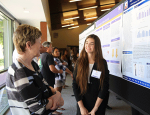 A student presents her research to President Herzberger