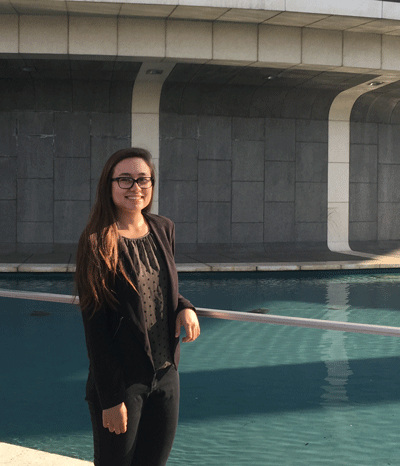 Jacklyn Waight, stands in front of a fountain and the back part of the Mark Taper Forum
