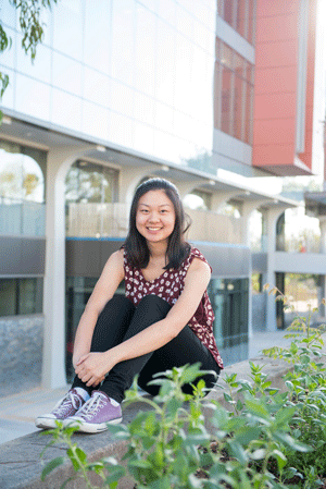 Katrina Wong sits on ledge in front of the science bulding