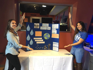 Students point to an information posted for World Water Day