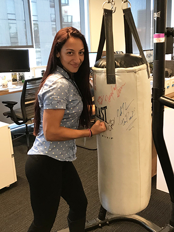 Madison Crimi-DeMichele stands by an autographed punching bag in the Bellator office.