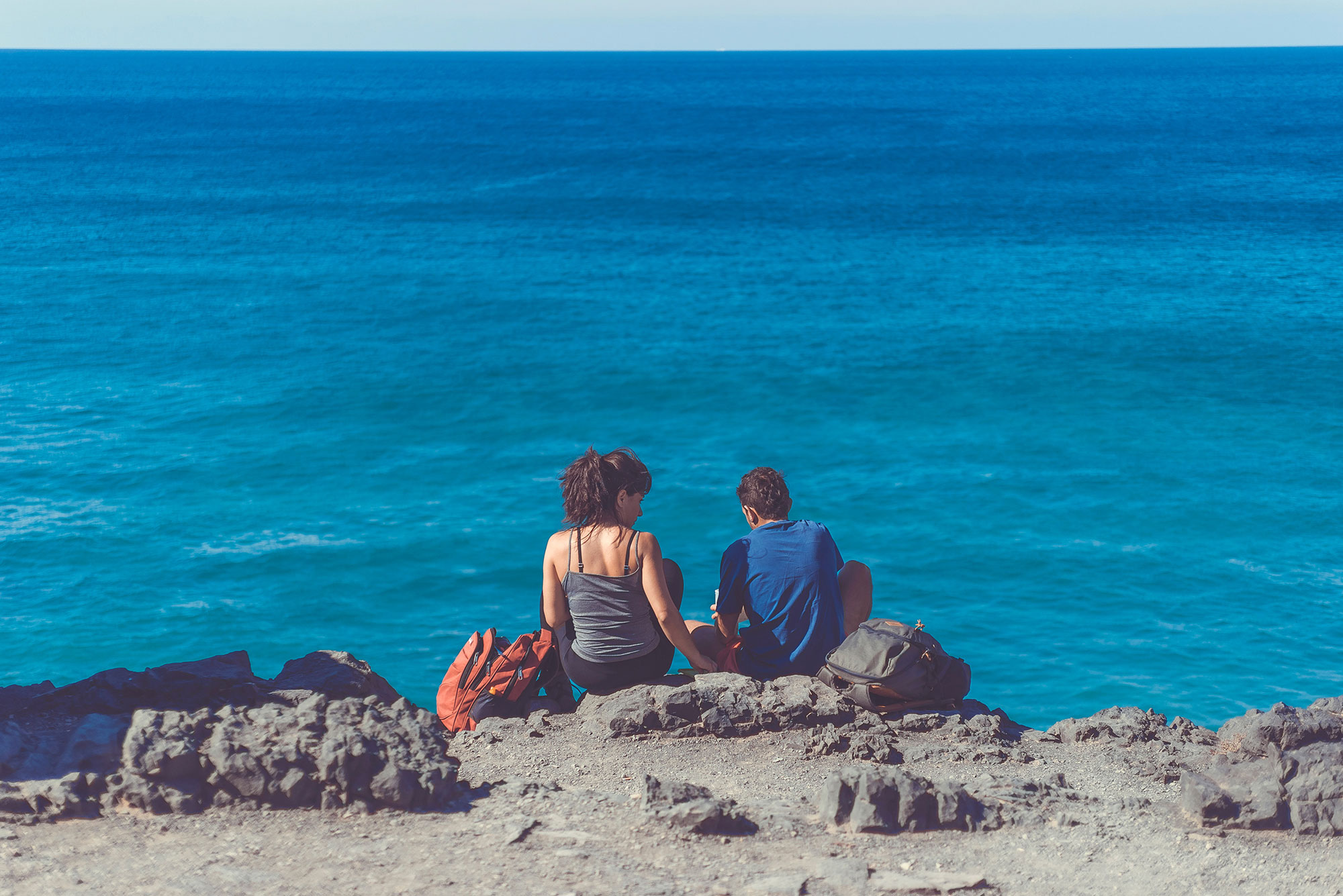 couple sitting near the ocean