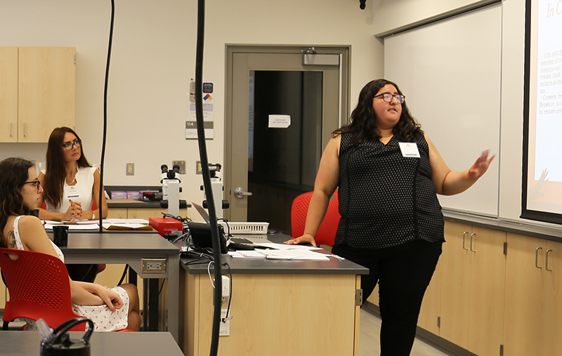 Daniela Vega presents a lecture in a classroom with a small group of women watching.