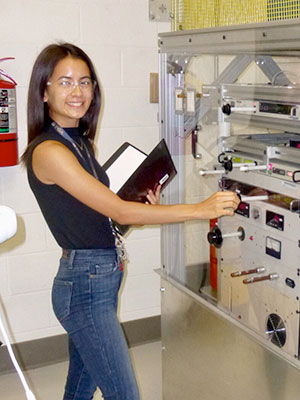 Emi Eastman stands in a physics lab.