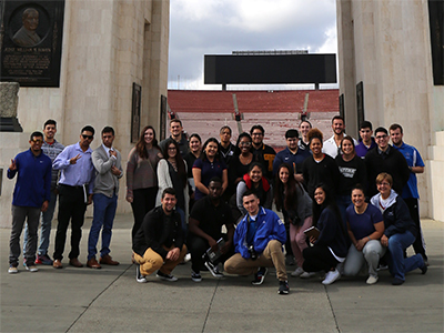 A sports management class poses as a group at the entrance to the L.A. Memorial Coliseum.