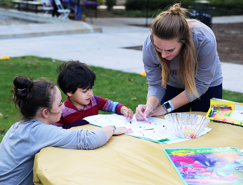 Student playing with two children