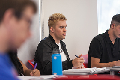 Trevor Tuma listens to a lecture in a classroom.