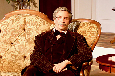 Theatre student Gunner Joachim sits on a sofa while wearing his detective costume from the play Gaslight.