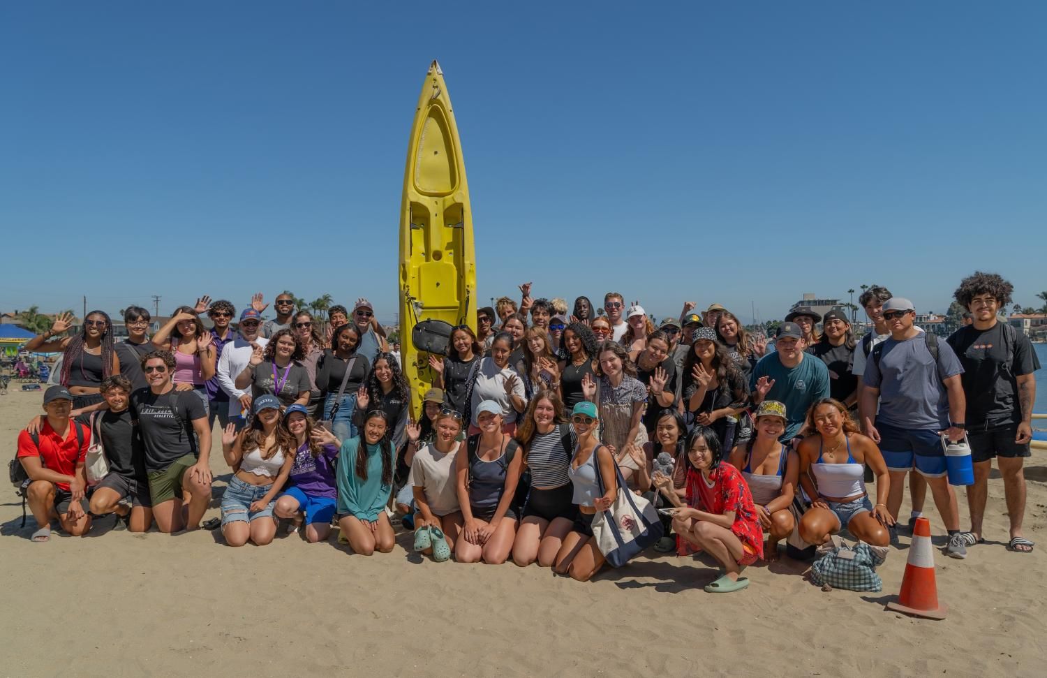 Group of Whittier College students on beach in front of Kayak