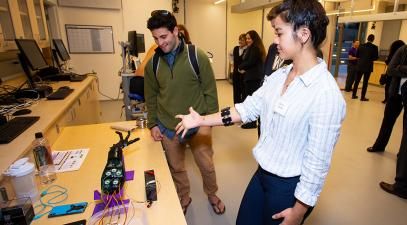 Danica Cooley demonstrates her myoeletric prosthetic arm to a student.