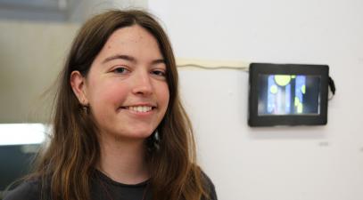 Lauren Swintek stands in front of her animated short, Celestial Bodies.