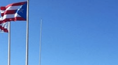 Picture of three flags next to the sea 